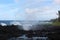 Small waves crashing into the black volcanic shoreline at Waianapanapa State Park, Hana, Maui