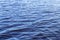 Small waves on the surface of the lake. Beautiful texture of blue water. On a sunny day.