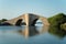 Small, wavy and steep old stone bridge over Mediterranean coast water way