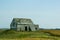 Small weathered building next to a corn field in North Dakota