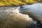 Small weir in a narrow stream from close