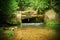 Small weir on river flows out from cave. Cold water of small river flow over small stony weir. Stony and rusty construction of we