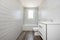 Small white bathroom with bathtub, white cabinet with drawers and sink on the right, with dark ceramic floor