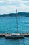 Small white boat harbored at a dock with a lovely view in the background