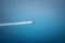 A small white boat rushes through the blue sea, a minimalistic s