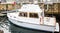 Small White Cabin Cruiser by Block Wall