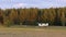 small white civil aircraft land on runway in field with forest in background. Rural airport where white and blue light