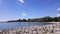 Small white clouds flowing in the sky over a pebble beach on Lake Mietkowskie