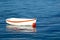 Small white dinghy with clinker lines and orange stripe