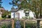 Small white rambler house with concrete walkway.