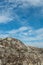 Small white seagull in clouds of blue sky shot from a texture rocks of island on Ladoga lake in Karelia