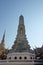 A small white tower that is located on the territory of the Temple of the Emerald Buddha. Religious architectural art of Southeast