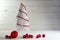 Small white wire christmas tree decorated with red baubles and b