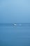 Small white yacht speeding away across the Kvarner gulf during the autumn rainstorm