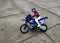 A small wind-up toy in the form of a rider on a motorcycle on the asphalt