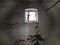 A small window at the top of the wall. Scary walls with cobwebs. Old church dormer. Halloween or haunted place. Prison cell with