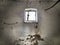 A small window at the top of the wall. Scary walls with cobwebs. Old church dormer. Halloween or haunted place. Prison cell with