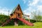 Small wood log playhouse hut with stairs ladder and wooden slide on children playground at park or house yard. Green grass lawn