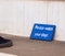 Small wood plate painted blue with hand written words  `please watch your step`on a stair as waring sign for english language tour