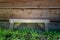 Small wooden bench on grass in front of waney edged wooden shed.