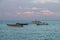 Small wooden boats, motorboats on ocean horizon in evening sun