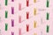 Small wooden colorful pegs.for loundry and paper on a pink background. Minimal design and pattern