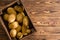 Small wooden crate filled with fresh potatoes