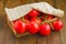 Small wooden crate with vibrant, freshly-picked red tomatoes covered with a towel.