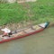 small wooden fishing boat leaning on the river bank