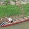 small wooden fishing boat leaning on the river bank