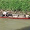 small wooden fishing boat leaning on the river bank