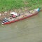 small wooden fishing boat leaning on the river bank