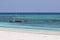 Small wooden fishing boat by white sand beach in Zanzibar