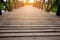 Small wooden foot bridge or walkway crossing over river and glowing light at the end of wooden ways.