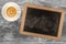 Small wooden framed blackboard with cup of coffee