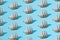 Small wooden home decoration pirate ship with white sails on a blue pastel background. Pattern. Minimal concept and design