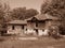 Small wooden house surrounded by trees.  Mountain shabby hut image of outdoor. Sepia colour.