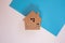 Small wooden house toys on a white and blue background.