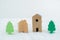 Small wooden model house and building with green trees in residential areas. Coexistence with nature concept.