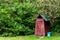 Small wooden outdoors toilet in summer