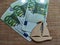 A small wooden or plywood flat toy ship and Euro banknotes next to it. The concept of the value of the toy, travel, and