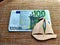 A small wooden or plywood flat toy ship and Euro banknotes next to it. The concept of the value of the toy, travel, and