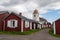 Small wooden red houses with a church tower in the background in the village of Gammelstad in northern Sweden.