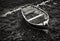 Small wooden rowboat moored at low tide