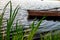 A small wooden rowing boat with a broken bottom on a calm lake near the shore