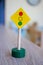 Small wooden traffic light sign on the wooden table under the lights with a blurry background