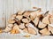 Small woodpile of dried logs in winter snow