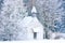 Small woody chapel in frozen snowy forest