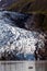 Small yacht dwarfed by massive glacier