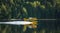 Small yellow airplane on pontoons takes off from a lake.